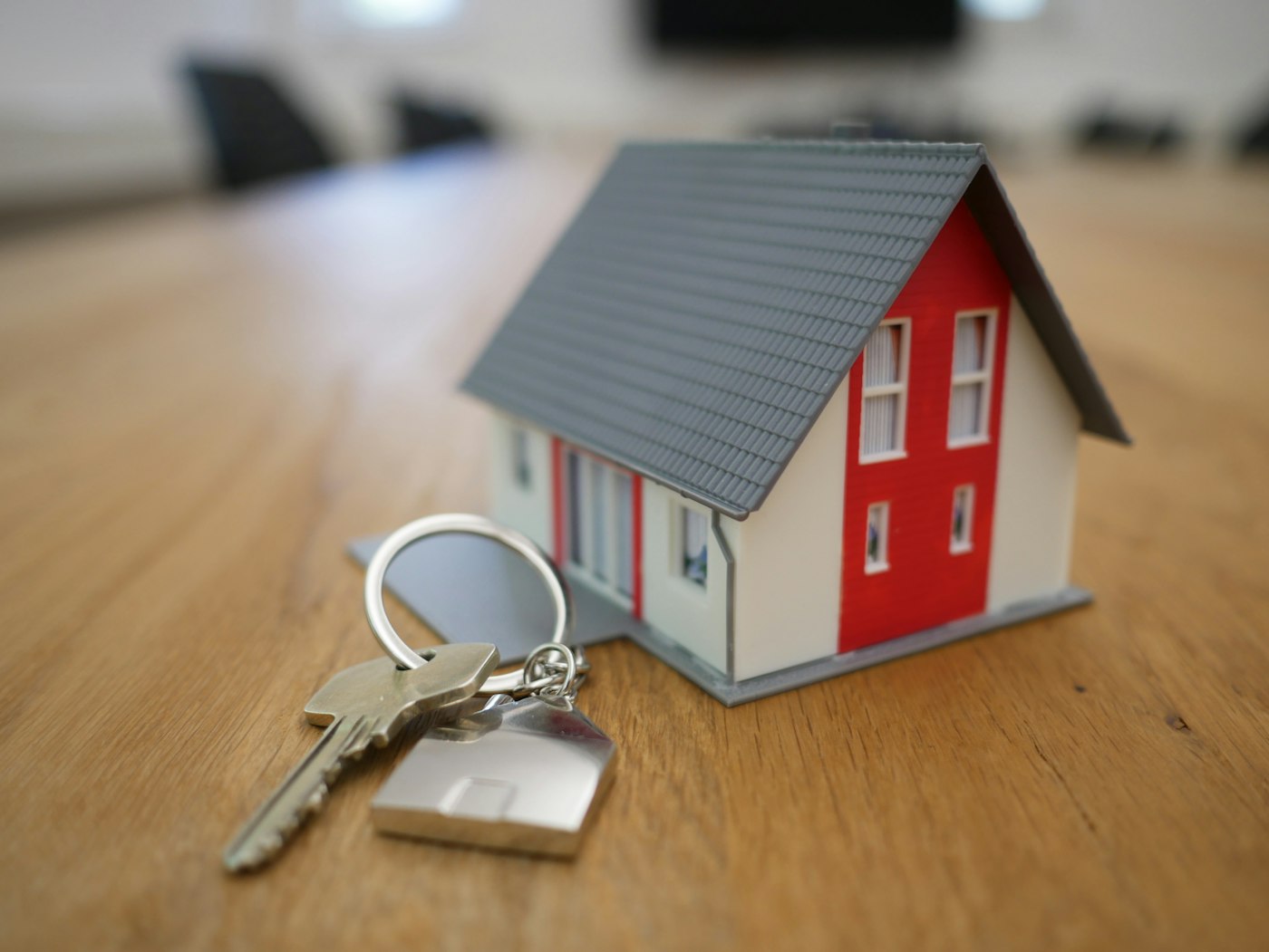 House keys beside a small model home on a table